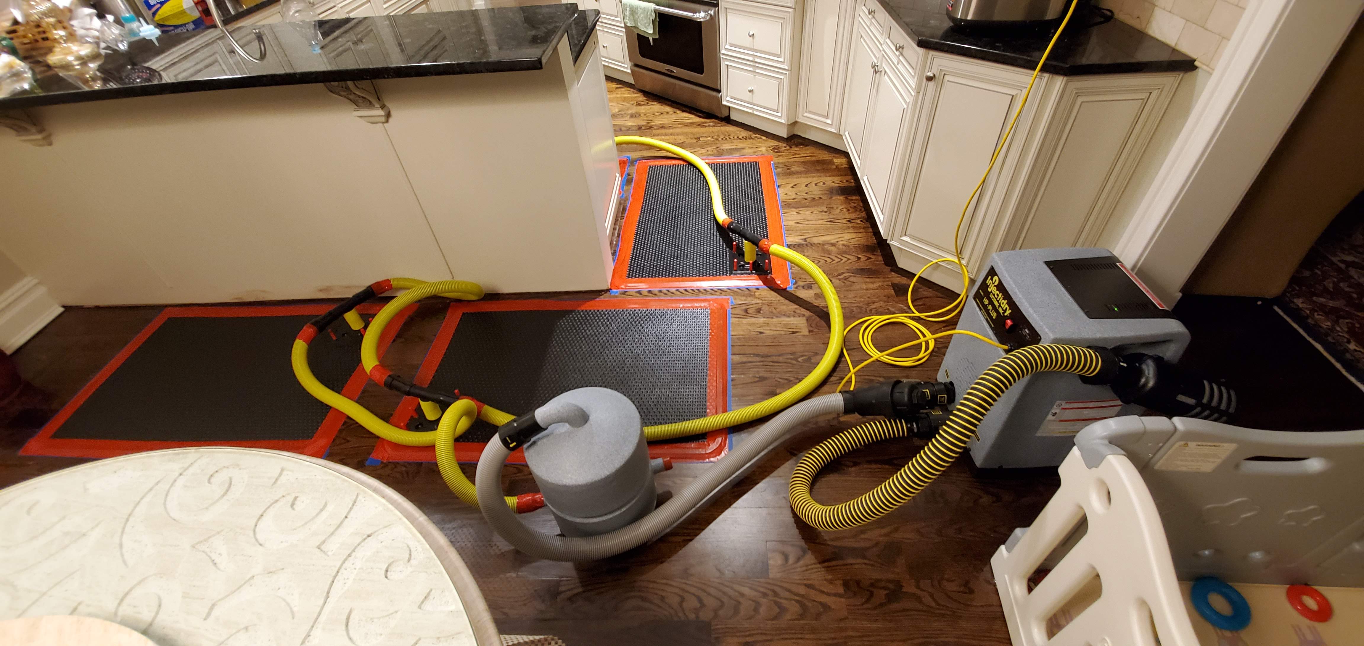 Water-damaged hardwood floor on Staten Island — cupped oak boards with raised edges after a supply-line leak